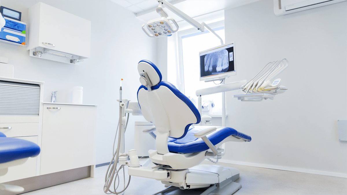 Close-up of dental equipment including dental chair, light, and tools