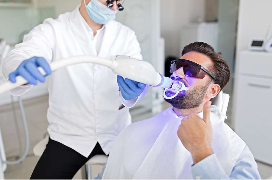 Man having a Teeth Whitening using dental instruments