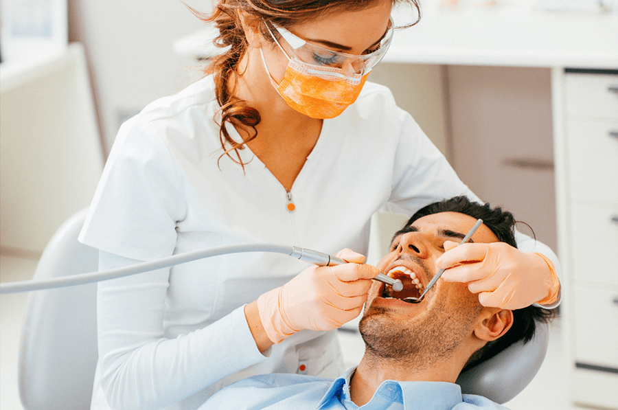 Man getting wisdom teeth extracted by dentist.